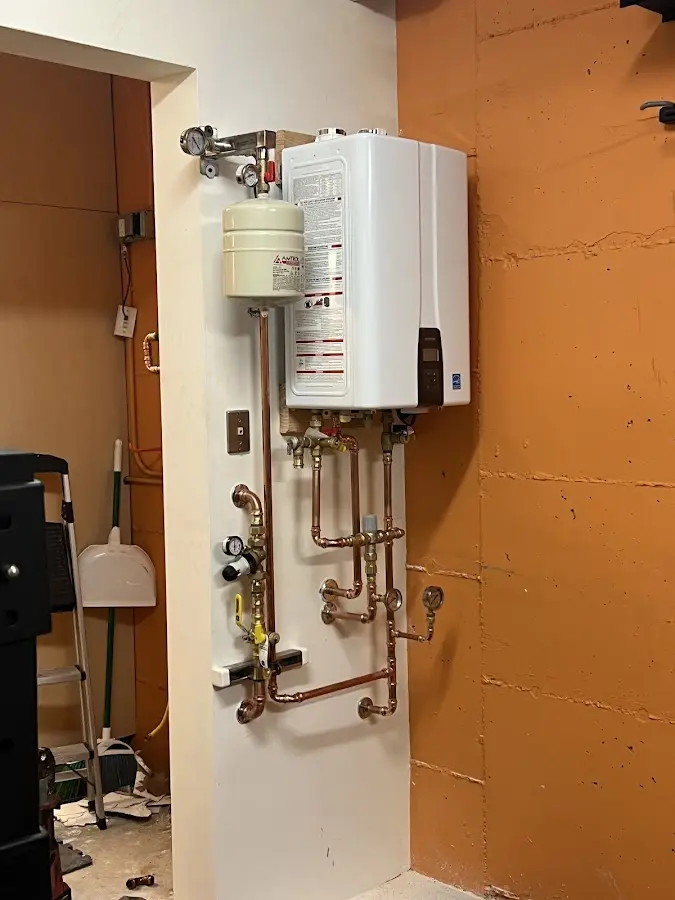 Plumbing technician inspecting water heater connections in Beloit